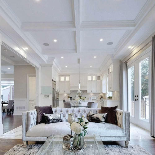 Bright open-concept living room featuring a custom white plaster-coated foam waffle ceiling (coffered ceiling) with integrated pot lighting and elegant crown mouldings.