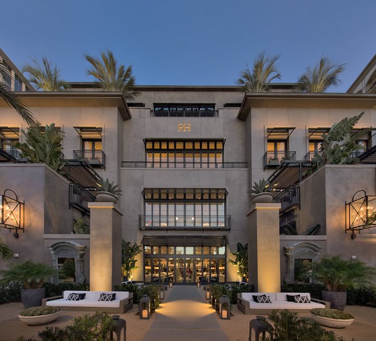 Grand exterior facade of a Restoration Hardware (RH) gallery featuring custom cement-coated foam architectural mouldings, decorative window headers, and integrated stone pillars.