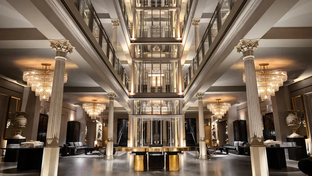 Grand hotel lobby featuring tall Corinthian columns and decorative architectural mouldings made from plaster-coated foam in a luxurious Restoration Hardware style.